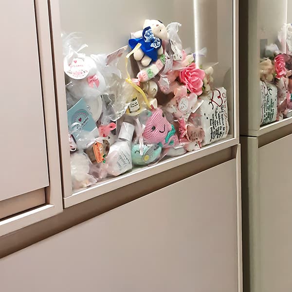 Vitrine repleta de lembrancinhas das mamães que tiveram bebes meninas.