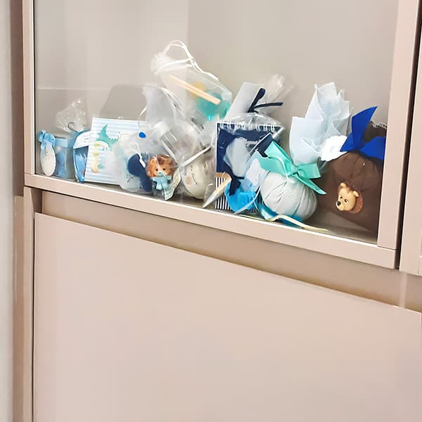Vitrine repleta de lembrancinhas das mamães que tiveram bebes meninos.