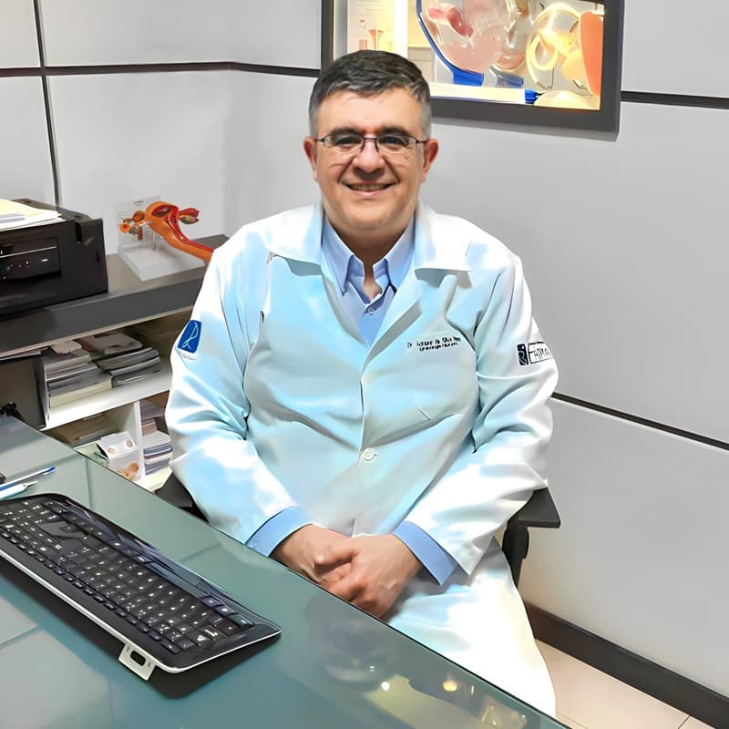 Dr. Adriano sentado, sorrindo e olhando para a câmera.