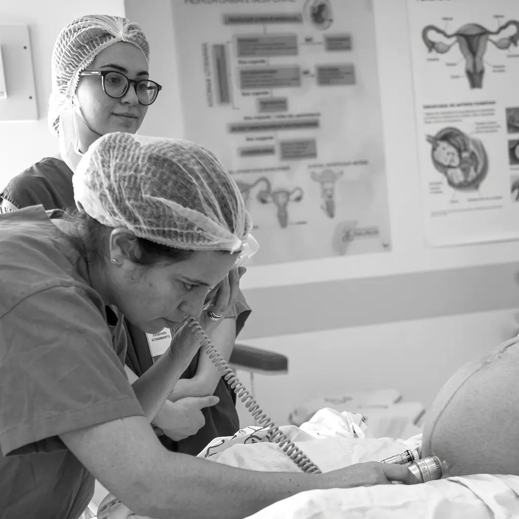 Dra. Mariana Romanowski monitorando os batimentos cardíacos do futuro bebê ainda dentro da barriga da mãe durante  a preparação para o parto em ambiente hospitalar