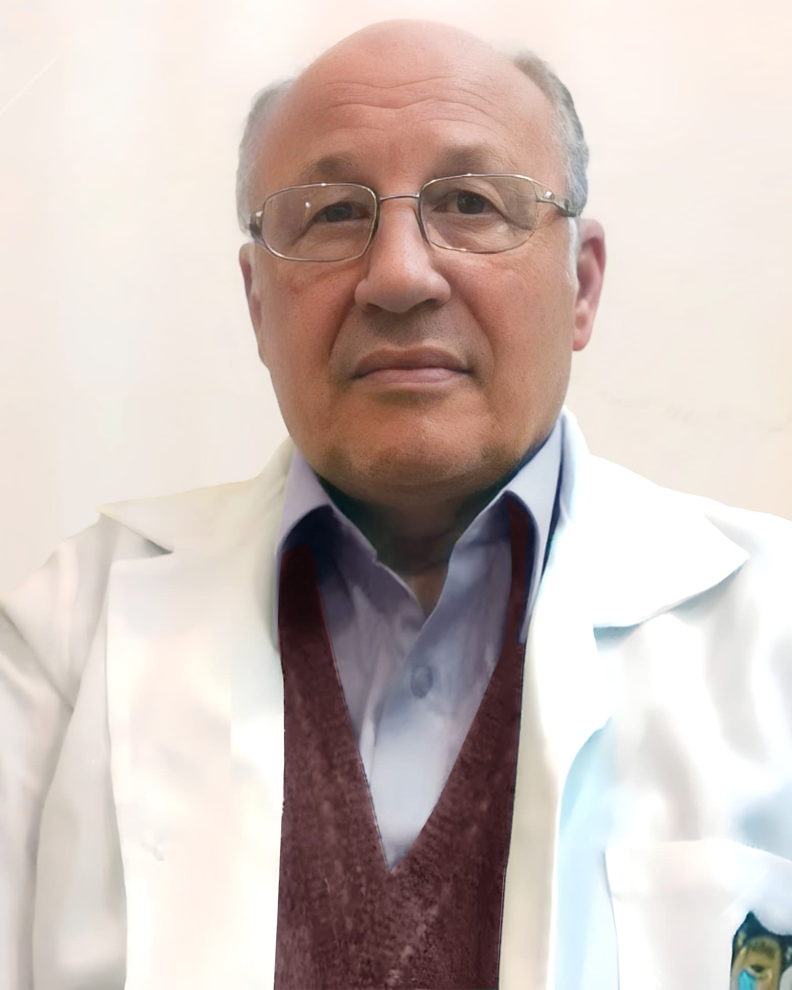 Dr. Wilson Bozzi de Sá, gastroenterologista em Curitiba, senhor simpático, poucos cabelos, aparentemente sentado em seu consultório, em close olhando de lado, sorrindo, usando óculos e vestindo jaleco branco, por trás uma parede bege.